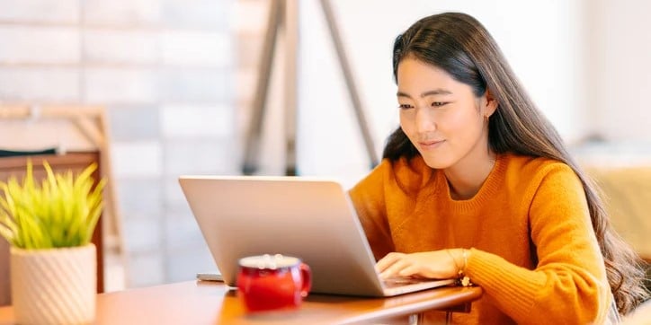 Woman seated at a computer using DocuWare eforms